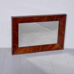 Unusual Victorian wall mirror in a figured mahogany frame with scalloped and gilded decorations