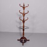 Late Georgian circular mahogany hall tree, surmounted by a turned finial over three rows of curved and shaped coat and hat hooks.